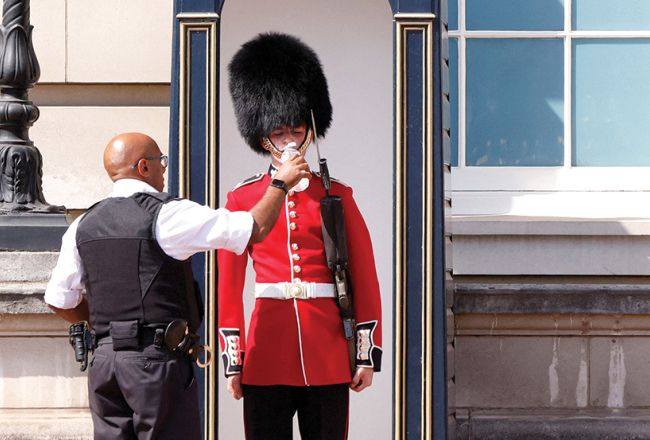 Bekingemas pils apsardzes darbinieks pasniedz ūdeni britu karaļnama goda sardzes karavīram.
Foto — Scanpix