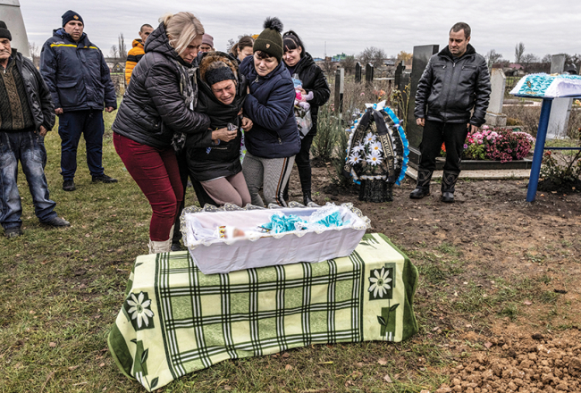 Marija Kamjaņecka ar māti un māsu sava dēliņa Serhija bērēs 25. novembrī. Mazuli Marija nēsāja visus deviņus kara mēnešus, un viņš gāja bojā tikai divas dienas pēc piedzimšanas, kad Krievijas raķete trāpīja dzemdību nodaļai Viļņanskas pilsētā Zaporižjas apgabalā.
Foto — The Washington Post
