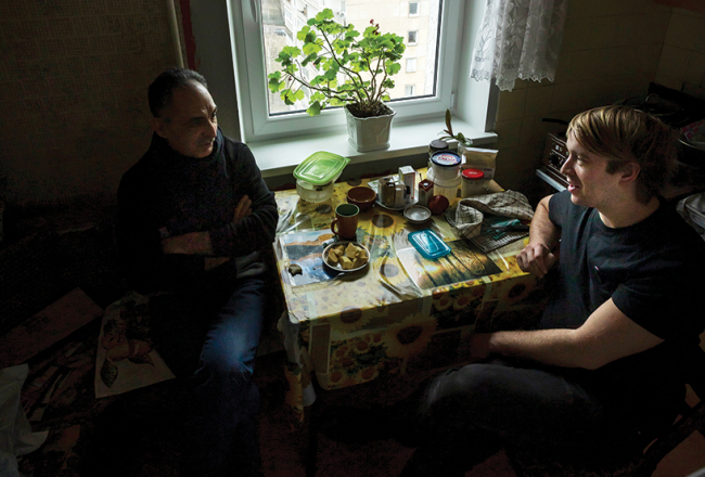 Staņislavs Tokalovs savas vecmāmiņas virtuvē kopā ar patēvu Raulu.
Foto — Ieva Salmane