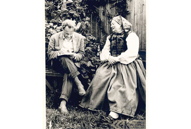Folklorists Jānis Rozenbergs pieraksta Nīcas teicējas Katrīnas Čirkšes stāstījumu zinātniskās ekspedīcijas laikā pagājušā gadsimta 60. gados.
Foto no LKF arhīva