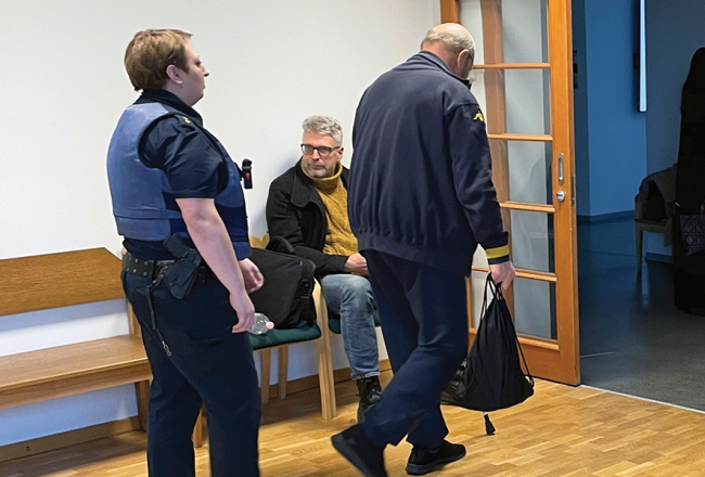Lato Lapsa un Mihails Uļmans (ar muguru) Mārtiņa Bunkus slepkavības tiesas sēdes pārtraukumā pagājušā gada februārī,