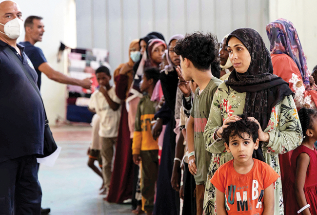 Tikko iebraukuši migranti pagaidu patversmē vienā no Grieķijai piederošās Krētas salas pilsētas Agijas domes ēkas zālēm pagājušā gada 10. jūlijā.