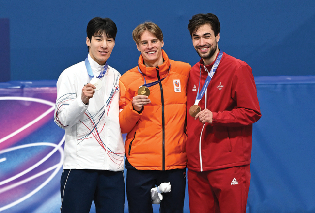 Olimpiskā 1500 m šorttreka pjedestāls: ar sudraba medaļu dienvidkorejietis Dehons Hvans (pa kreisi), ar zelta medaļu Jenss van ’T Vouts no Nīderlandes un bronzu ieguvušais latvietis Roberts Krūzbergs.