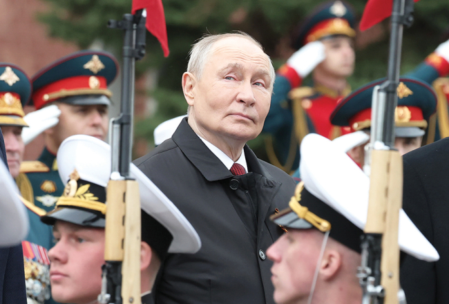 Krievijas diktators Vladimirs Putins 9. maijā Sarkanajā laukumā vēro parādi, kura, baidoties no ukraiņu triecieniem, notika bez militārās tehnikas izrādīšanas.