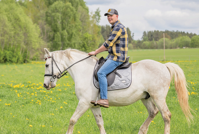Dainis baltā rikšotāja Hektora mugurā. Foto — Ieva Babre