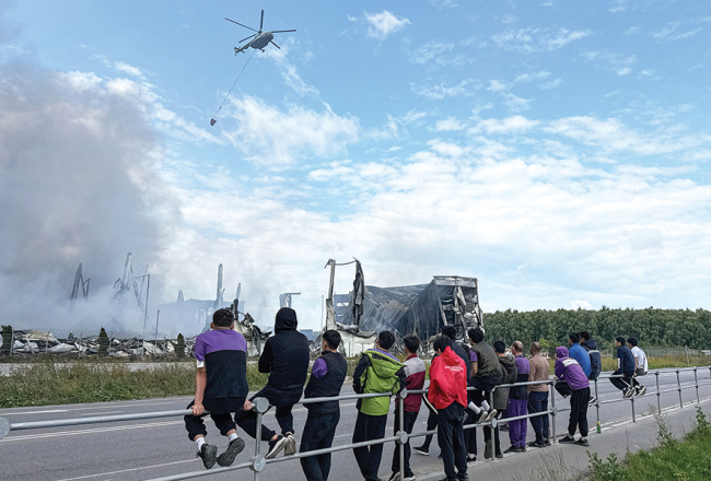 Ziņkārīgie vēro, kā 16. augustā pēc ukraiņu lidrobotu uzbrukuma tiek dzēstas tiešsaistes tirgotavas Wildberries loģistikas centrā krāsmatas Maskavas pievārtē.