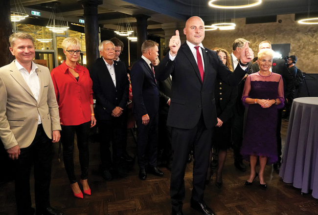 Andris Kulbergs (priekšplānā) ar saviem partiju apvienības  kolēģiem vēlēšanu dienas vakarā, gaidot balsojuma rezultātus.