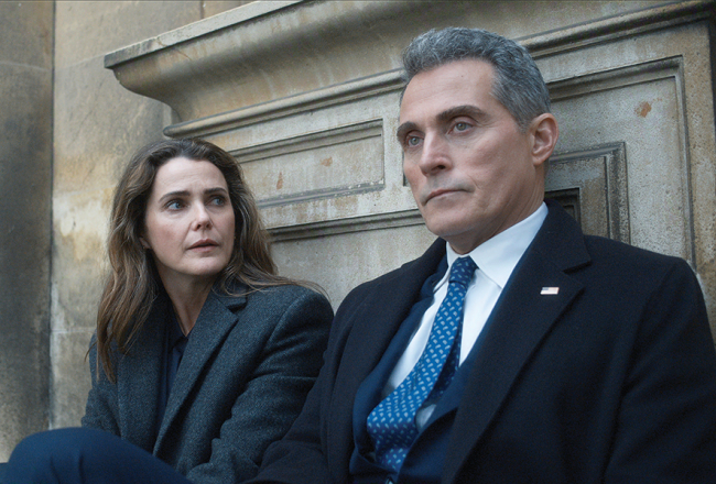 ASV vēstnieces Lielbritānijā lomā Kerija Rasela, viņas vīrs un diplomātisko aprindu pelēkais kardināls — Rufuss Sjūels. Publicitātes foto — Netflix