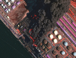 No satelīta uzņēmtā attēlā redzams plašs ugunsgrēks Ustjugas ostā 27. martā.