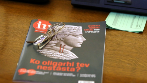 Žurnāla "Ir" speciālizdevums par oligarhu lietu uz Saeimas deputāta darba galda ārkārtas sēdē, kurā lēma par parlamentārās izmeklēšanas komisijas sastāvu. Foto: Edijs Pālens, LETA