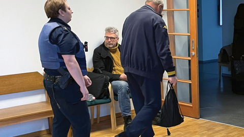 Lato Lapsa un Mihails Uļmans (ar muguru) Mārtiņa Bunkus slepkavības tiesas sēdes pārtraukumā pagājušā gada februārī,