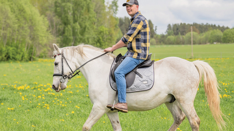 Dainis baltā rikšotāja Hektora mugurā. Foto — Ieva Babre