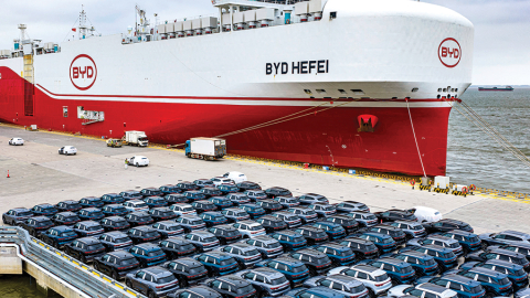 BYD elektroauto pirms iekraušanas kravas kuģī ostā pie Šanhajas.