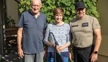 Dace Zaļkalne un viņas vīrs Andris no policista Vladimira Rudzīša rokām saņēma pašvaldības pateicību — lietussargu. Foto — Ģirts Gertsons