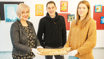 Aizputes Novadpētniecības muzeja vadītāja Jolanta Berga (no kreisās), pētnieks Andris Vasiļevskis un krājumu glabātāja Iveta Zomberga rāda pērn atgūto mamuta kaulu.