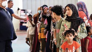 Tikko iebraukuši migranti pagaidu patversmē vienā no Grieķijai piederošās Krētas salas pilsētas Agijas domes ēkas zālēm pagājušā gada 10. jūlijā.