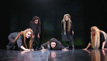 Izrādes centrā ir Jūlijas Ļahas spēlētā Hekube, kuru atbalsta sieviešu koris. Publicitātes foto