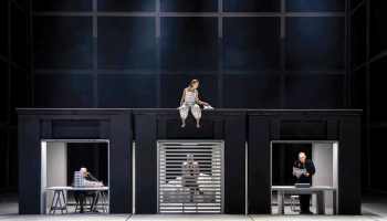 Scenogrāfs Reinis Dzudzilo Pirmavota pasauli redz kā koordinātu sistēmu, kurā ik ķermenis pūlas atrast savu vietu, kamēr atšķirīgās darbības vides iezīmējošās kastītes rāda, cik daudzi spēlētāji rausta pavedienus katrs savā virzienā.