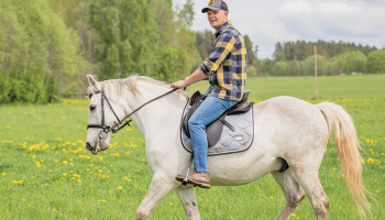 Dainis baltā rikšotāja Hektora mugurā. Foto — Ieva Babre