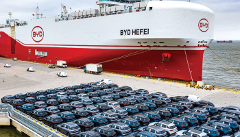 BYD elektroauto pirms iekraušanas kravas kuģī ostā pie Šanhajas.