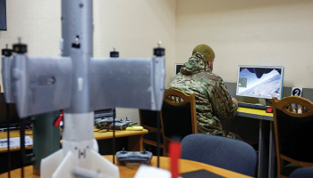 Privāta apsardzes uzņēmuma darbinieks ar simulatoru apgūst pārtvērējdronu vadību.