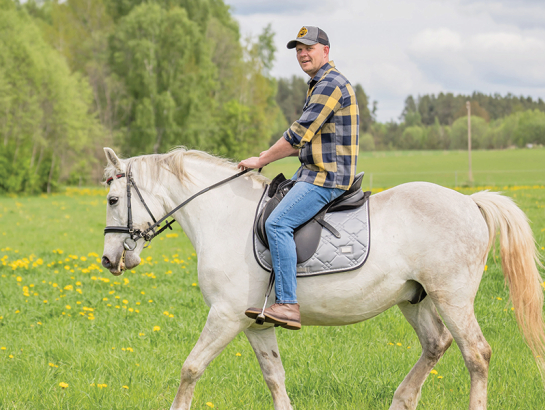 Dainis baltā rikšotāja Hektora mugurā. Foto — Ieva Babre