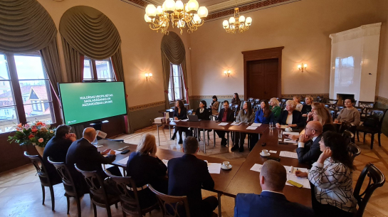 2025. gada 28. oktobra 14. Saeimas Valsts pārvaldes un pašvaldības komisijas sēde Kuldīgas jaunajā rātsnamā, aiz loga vecais rātsnams un vecākā Kurzemes koka ēka. Kristīnes Jarinovskas foto.