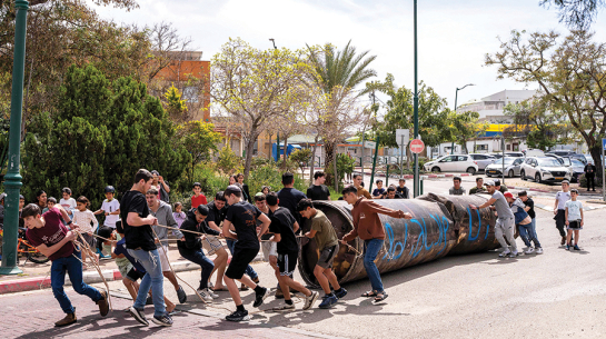 Ebreju kolonisti velk notriektās irāņu raķetes paliekas, kas nokrita pie Peduelas nometnes okupētajā Rietumkrastā.