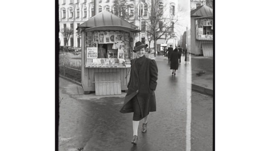 Sieviete pie avīžu kioska Marijas ielā Rīgā. 1935.—1939. gads. Foto — Alberts Neilands. Latvijas Nacionālā arhīva krājums