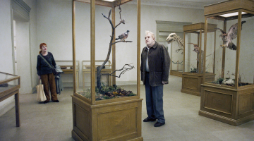 Kadrs no zviedru absurda traģikomēdijas Balodis apsēdās uz zara, prātojot par eksistenci, kas saņēma Venēcijas kinofestivāla galveno balvu.