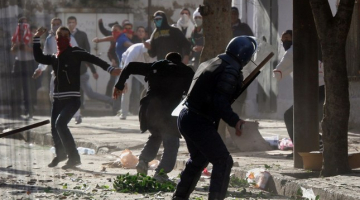 Protestētāji Alžīrā ar akmeņiem apmētā policistus. Foto: AFP/LETA