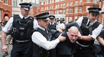 Britu policisti saņem ciet Asanža atbalstītāju. Foto: AFP/LETA
