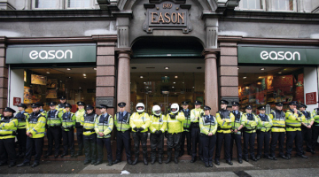Policijas «mūris» pie grāmatnīcas Dublinā, kur 4.septembrī Tonijs Blērs ieradās uz prezentāciju un autogrāfu sniegšanu. Viņu sagaidīja aptuveni 200 protestētāji. Foto — AFP/LETA
