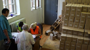 Cilvēki saņem pārtikas pakas trūcīgajiem biedrības "Latvijas Sarkanais Krusts" naktspatversmes telpās Gaiziņa ielā. Foto: Edijs Pālens, LETA