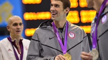 ASV peldētājs Maikls Feplss ar Londonā ceturtdien izcīnīto zelta medaļu 200 metru peldējumā. Foto: AFP/LETA