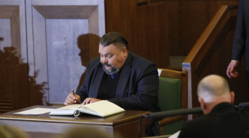 SC deputāts Valērijs Kravcovs paraksta 10.Saeimas deputāta svinīgo solījumu. Foto: Andrejs Strokins, F64