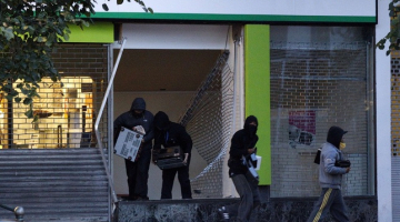 Laupītāji Birmingemā aplaupa elektropreču veikalu. Foto: AFP/LETA