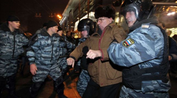 Miliči 15.decembrī aiztur cilvēkus pie Kijevas stacijas Maskavā, lai nepieļautu grautiņu izcelšanos. Foto: AFP/LETA