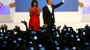 Mišela un Baraks Obama inaugurācijas ballē. Tūkstošiem roku ar mobilajiem telefoniem fotografē. Foto: AFP/LETA