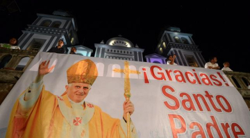 Ticīgie plakātā pateicas pāvestam Benediktam XVI. Foto: AFP/LETA