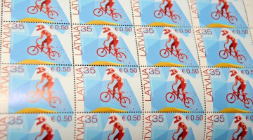 Jāņa Uzrauga veidotā pastmarka par godu BMX velosportam ir pirmā pastmarka ar nominālvērtību latos un eiro. Foto: Evija Trifanova, LETA