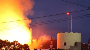 Degošā Rīgas pils. Tornī joprojām it simboliski plīvo valsts karogs. Foto: Egons Ansbergs, F64