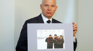Žoržs Tikmers preses konferencē rāda, kā izskatīsies Latvijas izlases tērpi. Foto: Ieva Lūka, LETA