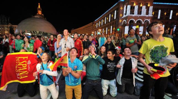 Spānijas futbola fani Kijevas centrā vēro pusfināla spēli. Foto: AFP/LETA