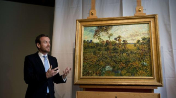 Muzeja direktors Aksels Rīgers pie jaunatklātās Vinsenta van Goga gleznas "Saulriets Monmažūrā". Foto: AFP/LETA