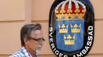 Kāds vīrs iet garām Zviedrijas vēstniecības ēkai Minskā. Foto: EPA/LETA