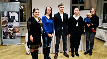 Literārā konkursa "Gunāra Astras un viņa līdzgaitnieku loma mūsdienu sabiedrībā" laureāti: (no kreisās) 3.vietas ieguvēja Anastasija Smirnova, Rita Kurele, Guntis Ozols, otrās vietas ieguvēja Zane Bondare un uzvarētāja Anna Elizabete Griķe ar dēliņu. Foto: Inese Kalniņa