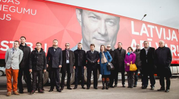 Partijas "Latvijas attīstībai" kandidāti pie fūres, kas reklamēs partiju pirms EP vēlēšanām. Publicitātes foto