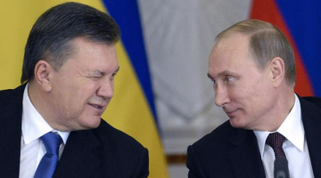 Pagājušā gad 17.decembris. Ukrainas prezidents Viktors Janukovičs miedz ar aci tikšanās laikā Krievijas prezidentam Vladimiram Putinam. Foto: AFP/LETA