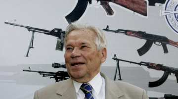 Mihails Kalašņikovs fotografēts 2007.gadā. Aiz viņa redzams leģendārais ierocis. Foto: AFP/LETA